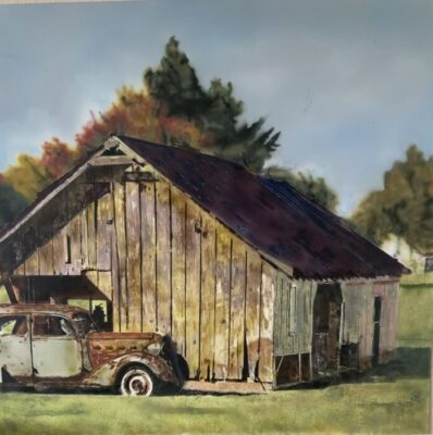 Rusting sports car in front of a barn